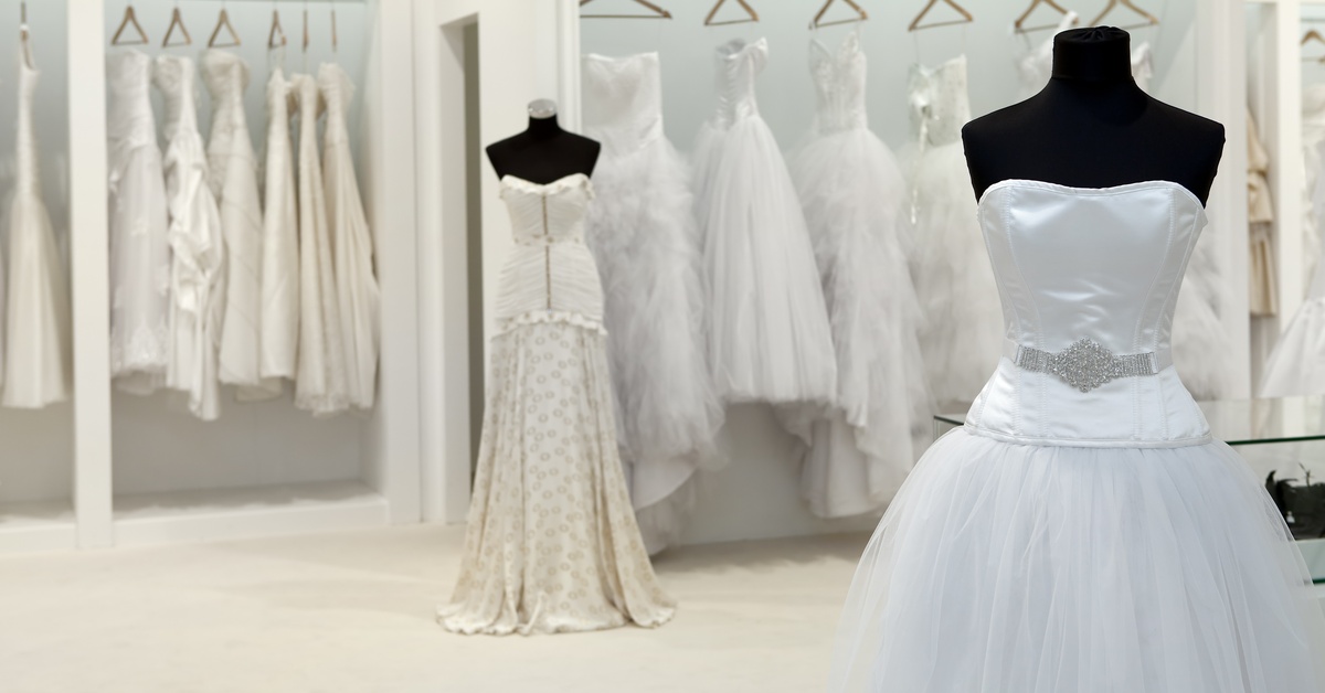 Two mannequins in a boutique shop are fitted with elegant bridal gowns, displaying their distinct features.